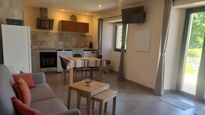 Un soggiorno moderno con un divano grigio, un tavolino in legno e una TV a parete.