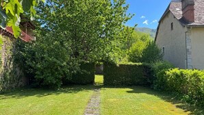 Een verzorgde tuin met een pad van stenen dat naar een gebouw leidt.