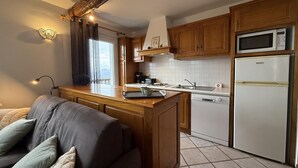 Une cuisine moderne avec des meubles en bois, un four à micro-ondes encastré et un réfrigérateur.