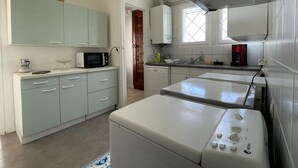 A compact kitchen with a washing machine, a microwave, and a coffee maker. - LACAZE-BUSQUET - GELOS (GELOS)