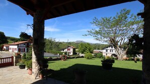 A stone-paved patio with a view of a rural landscape, including houses and a mountain in the distance. - Haizteia - Saint-pee-sur-nivelle (SAINT-PEE-SUR-NIVELLE)