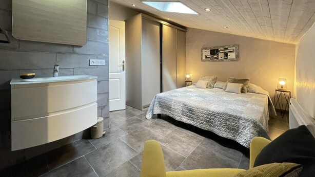 A modern bedroom with a large bed, a built-in vanity, and a skylight. - Xokoan - Sare - Gîte (SARE)