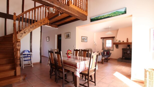 A dining area with a wooden staircase, a dining table with chairs, and a fireplace. - Ur-ondoa - Larceveau (LARCEVEAU)