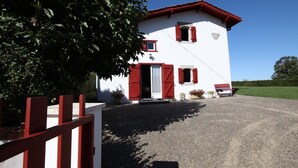 A white building with red shutters, a gravel driveway, and a red fence. - Ur-ondoa - Larceveau (LARCEVEAU)