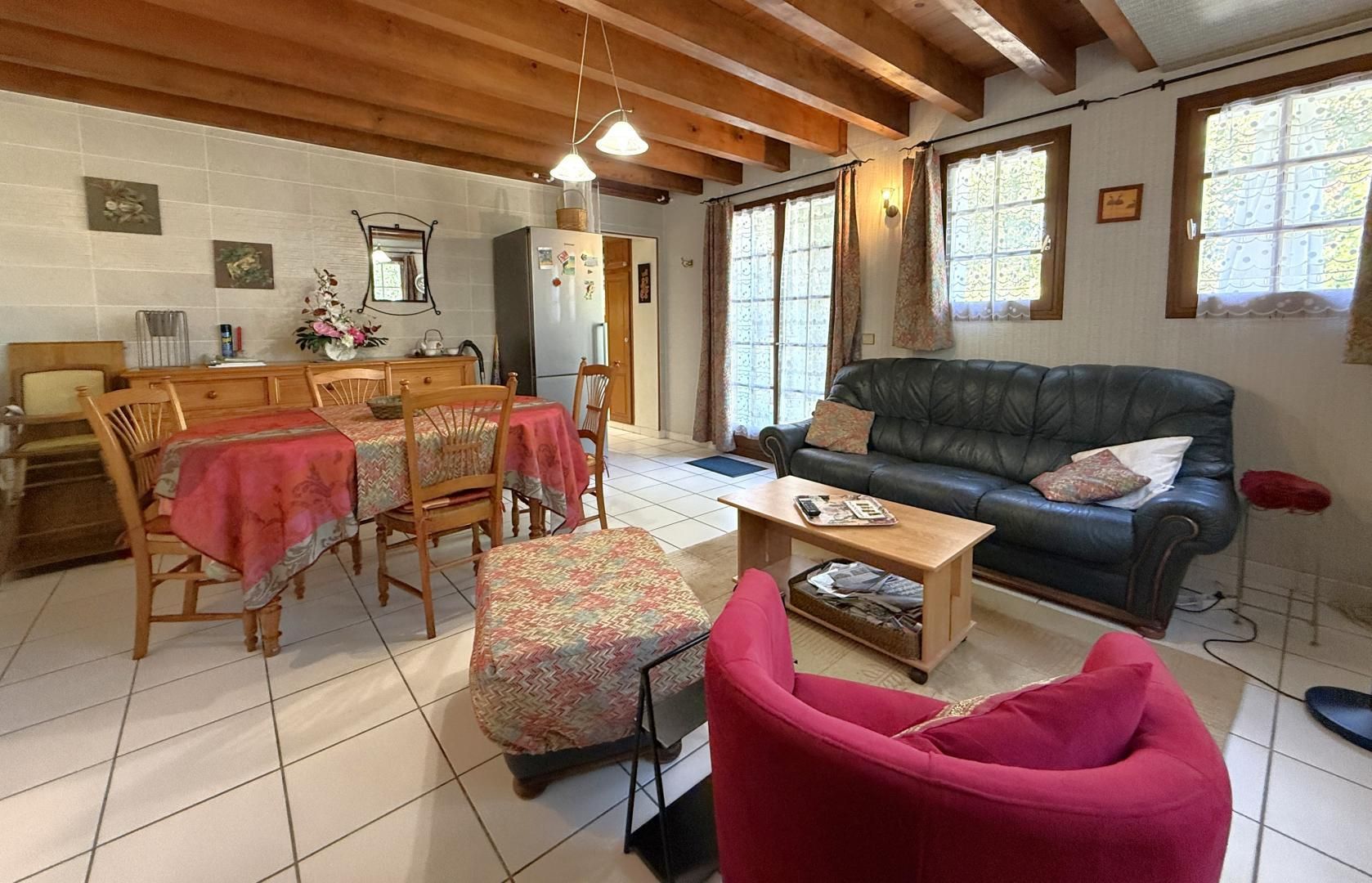 Un salon chaleureux comprenant un coin repas, un canapé et une table basse.