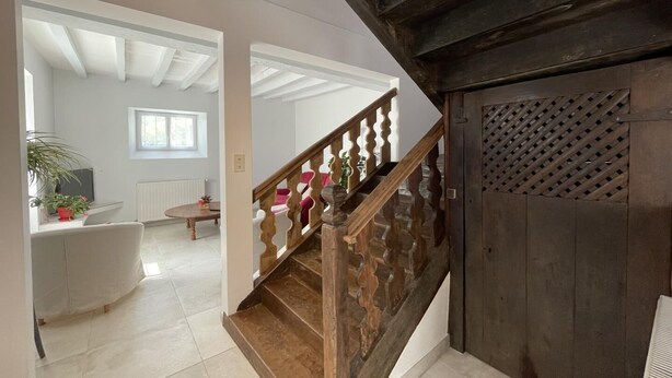 A staircase with wooden railings leading to an upper floor. A white radiator and a window are visible in the background. - Etchechoury - Moncayolle Larrory Mendibieu (MONCAYOLLE LARRORY MENDIBIEU)