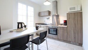Una cucina moderna con zona pranzo, che include un bollitore, una macchina da caffè e un forno a microonde.