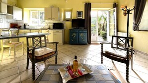 A compact kitchen with a dining area, a television, and a view of the outdoors. - CHEZ CASTAGNET - ASSAT (ASSAT)