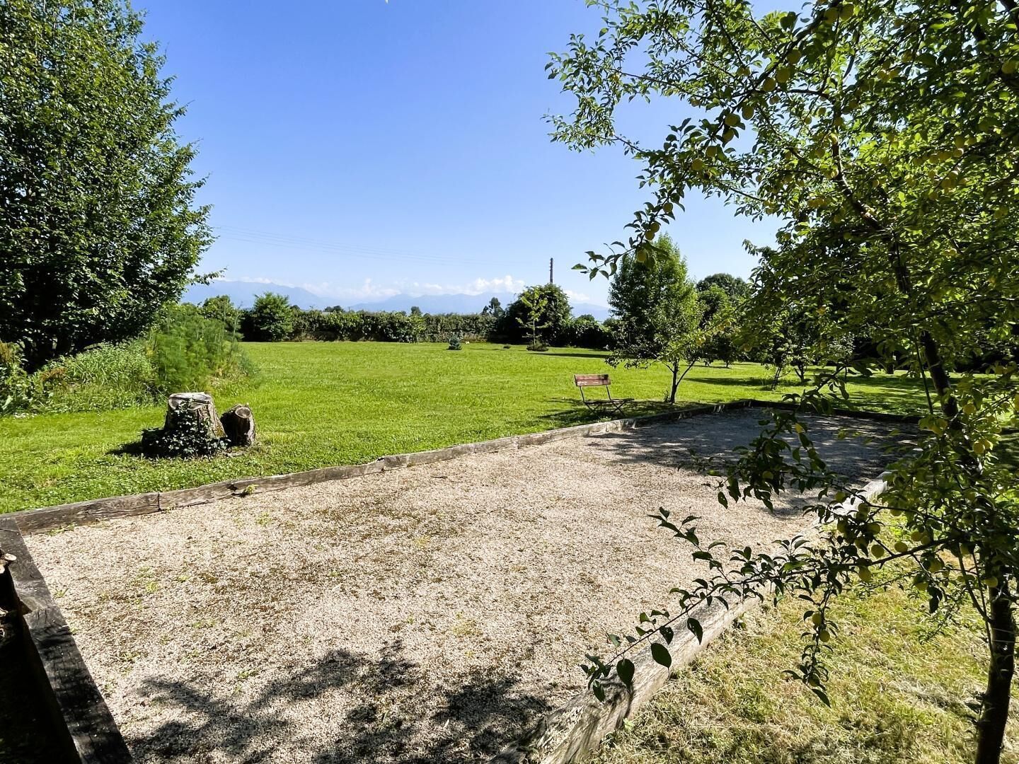 A grassy field with a bench and a wooden post.