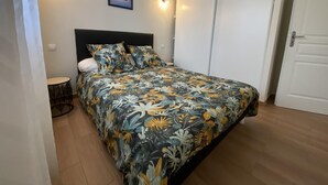 A bedroom with a bed, a round table, and a door. - Maliania - Arbonne - Gîte (ARBONNE)