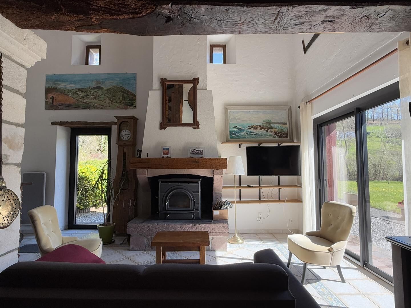 A living room with a fireplace, a television, and a large window.