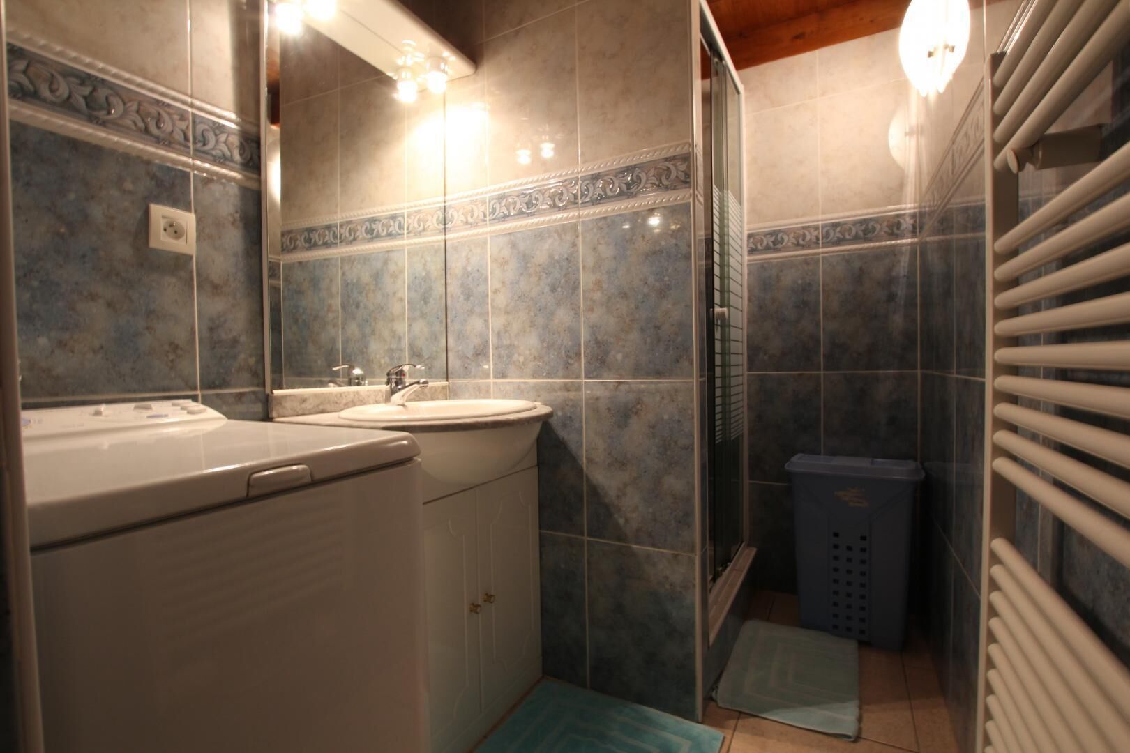 A compact bathroom with a sink, mirror, and shower.