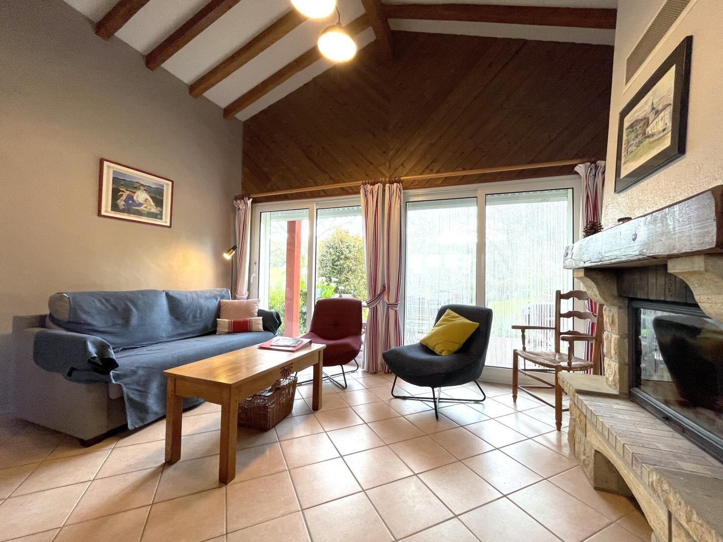 Ein gemütliches Wohnzimmer mit einer Couch, einem Sessel und einem Kamin.