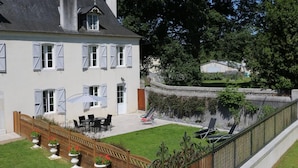 A two-story house with a patio area, outdoor furniture, and a garden. - Domaine Pedelaborde - Poey-d'oloron (POEY-D'OLORON)
