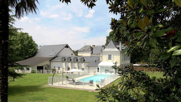 A large house with a swimming pool, surrounded by a white fence and lush greenery. - Domaine Pedelaborde - Poey-d'oloron (POEY-D'OLORON)
