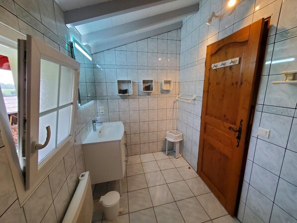A bathroom with a toilet, sink, and shower.