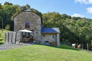 A stone farmhouse with a small attached barn, outdoor seating area, and a fenced pasture with horses. - La Bourdénabo - Lasseubetat (LASSEUBETAT)