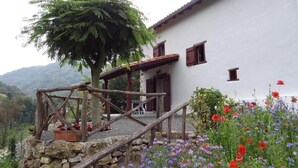 A rustic stone staircase leading to a wooden deck with a white building in the background. - PUTTIKO - BANCA - Gîte (BANCA)