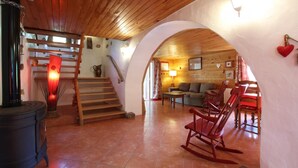 A rustic interior with a wooden staircase, a fireplace, a sofa, and rocking chairs. - PUTTIKO - BANCA - Gîte (BANCA)