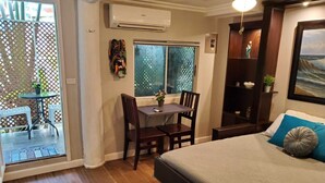 Une chambre à coucher avec un lit, un bureau et une chaise. Il y a une fenêtre donnant sur l’extérieur.