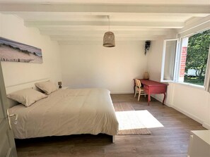 Un dormitorio con una cama, un escritorio y una ventana.