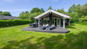 A modern outdoor patio area with a dining set and lounge chairs. - Lovely home in Vejby with kitchen (Vejby)