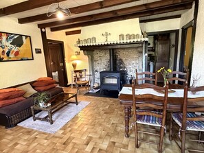 Un salon chaleureux avec une cheminée, des meubles en bois et un tableau accroché au mur.