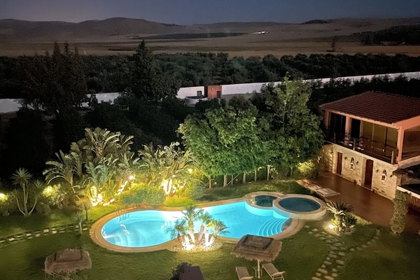 Een buitenzwembad, parasols voor strand/zwembad