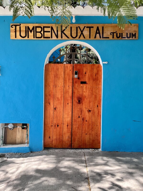 A wooden gate with a sign above it reading "TUMBENKUXTAL TULUM". - Tumben Kuxtal Tulum (Tulum)
