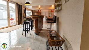 A bar area with stools, a wooden bar counter, and a wicker basket.