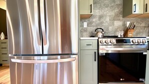 A kitchen with a stainless steel refrigerator, a built-in oven, and a gas stove.