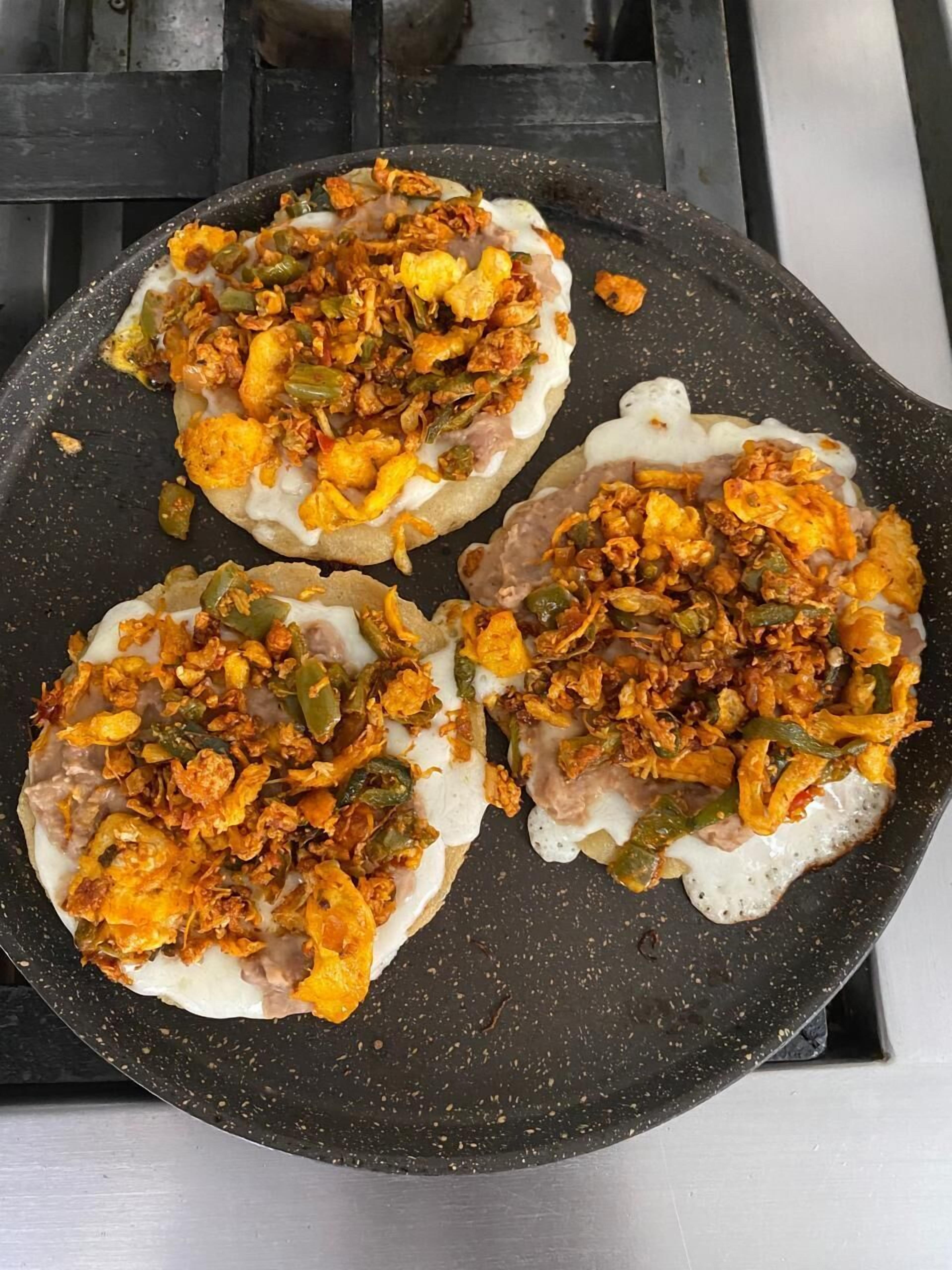 Three food items on a black pan.