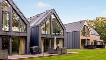 A modern house with large windows and a sloped roof.