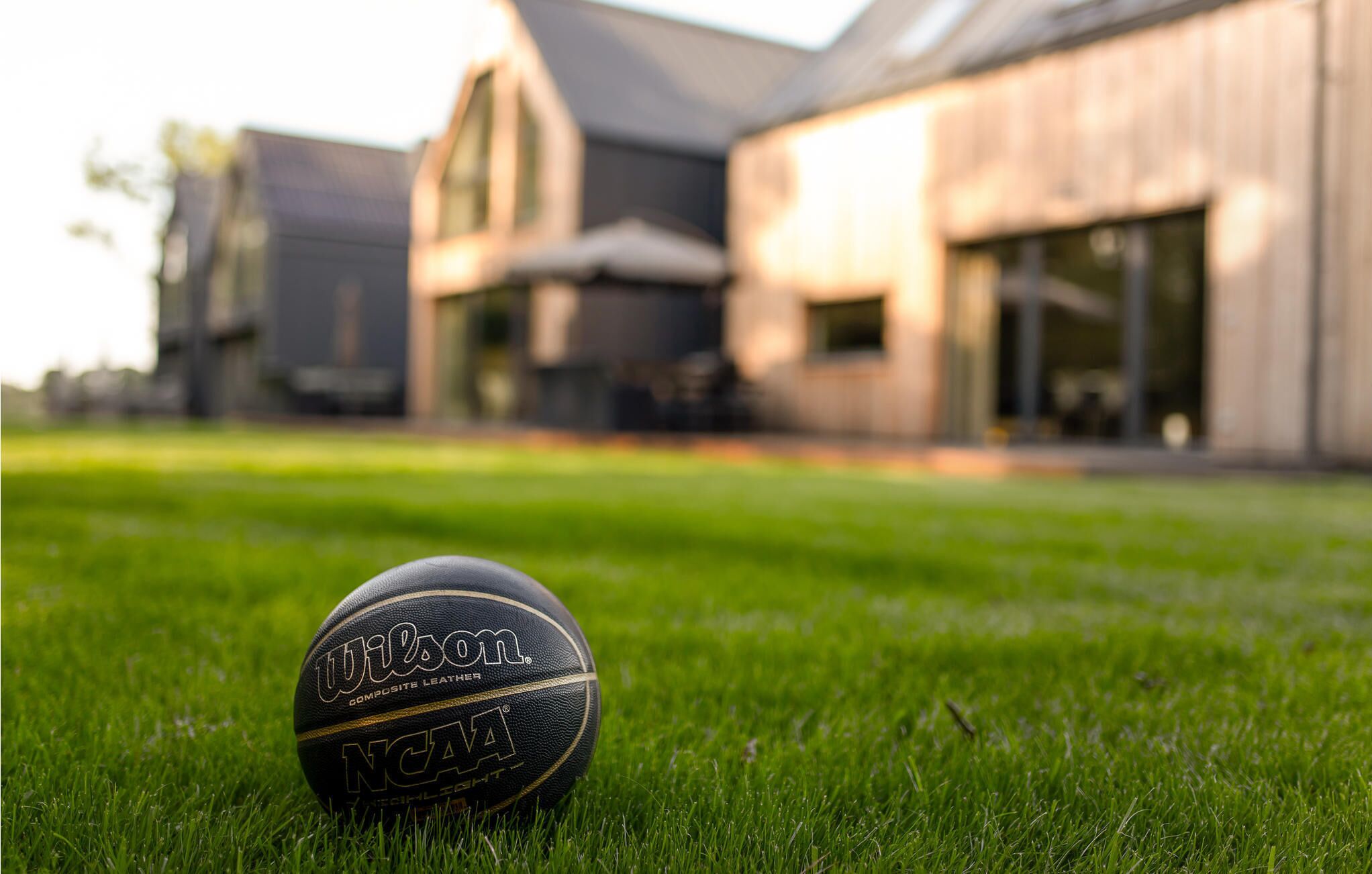 A golf ball on a grassy lawn with a building in the background.