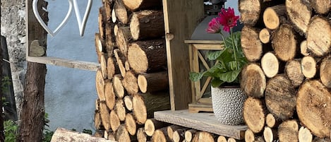 A rustic cabin with a log exterior, a small window with a flower, and heart-shaped decorations.