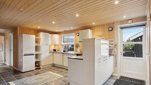 A modern kitchen with white cabinets, a central island, and a large window. - Lovely home in Strandby with WiFi (Strandby)