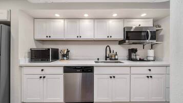 Een koelkast, een magnetron, een kookplaat, een vaatwasser