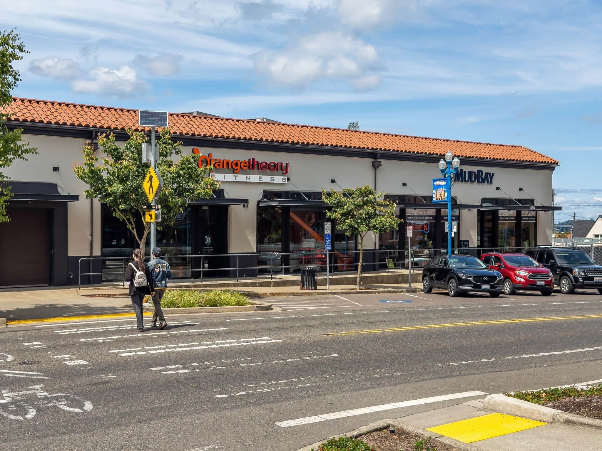 A street view with a building labeled 'OrangeTheory Fitness' and 'MudBay' across the street.