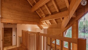 Un interior de madera con una escalera que lleva a un balcón.