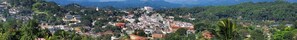 A densely packed urban area with buildings and greenery, surrounded by mountains. - MPM Apartment -Manawickrama Building  (Kandy)