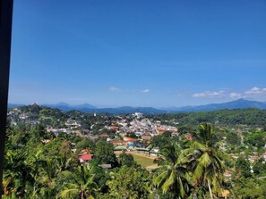 A town with a mix of residential and commercial buildings, surrounded by lush greenery and hills in the background. - MPM Apartment -Manawickrama Building  (Kandy)