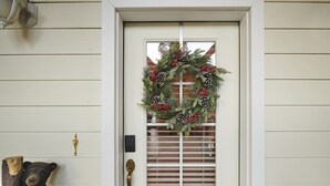 A white door with a wreath, a brass doorbell, and a bear statue. - Scenic Mountain Views w/ Game Room, Pool & Hottubs (Oakhurst)