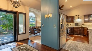 A modern kitchen with dark wooden cabinets, a stainless steel refrigerator, and a large island.