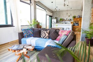 A modern living room with a sofa, coffee table, and potted plants.