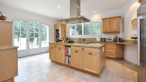Une cuisine moderne avec des meubles en bois, un îlot central et une grande fenêtre qui laisse entrer la lumière naturelle.