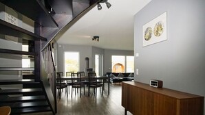 Ein modernes Interieur mit Treppe, Essbereich und Wohnbereich.