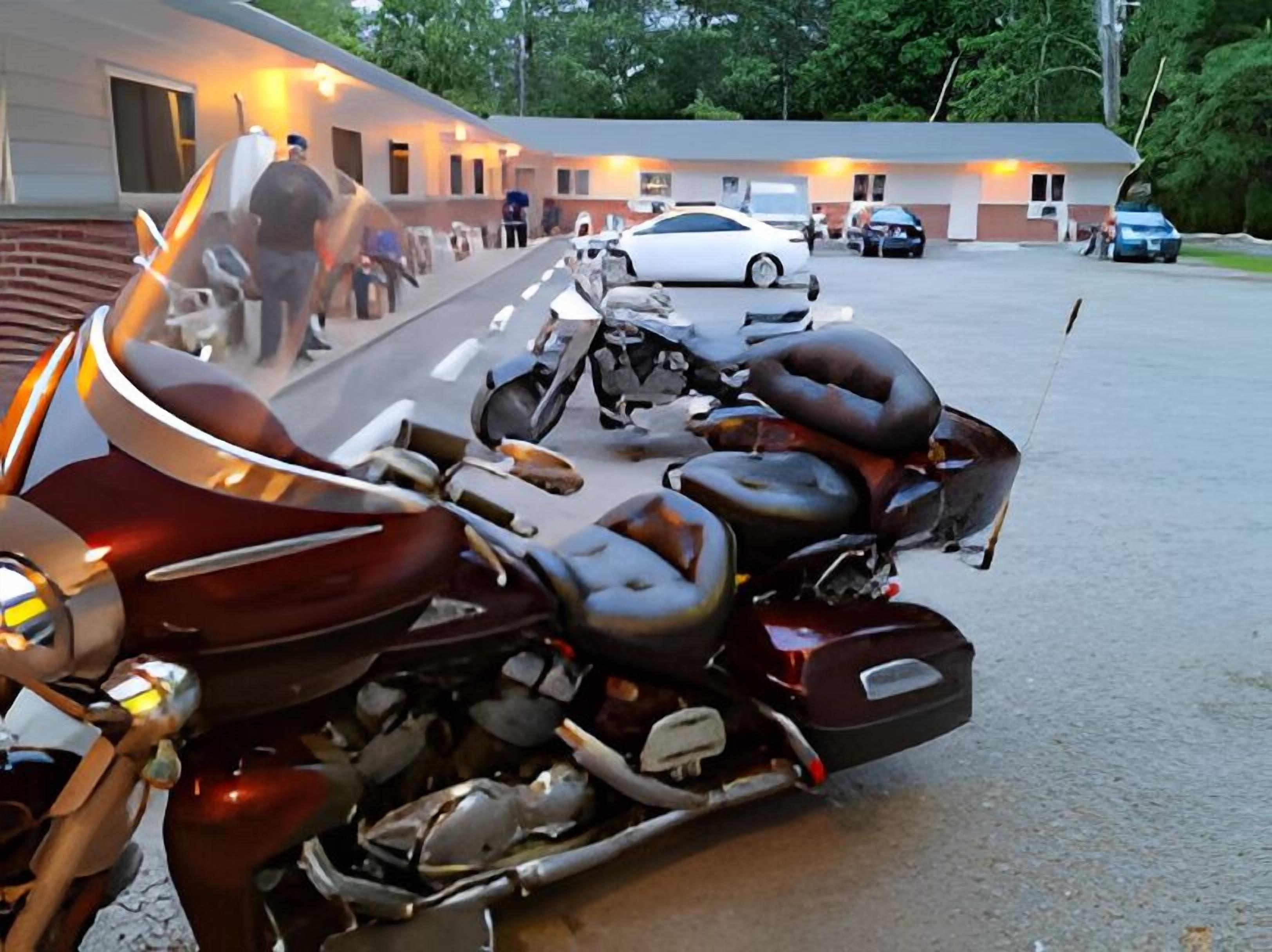 A motorcycle parked in front of a building with a ramp leading to the entrance.