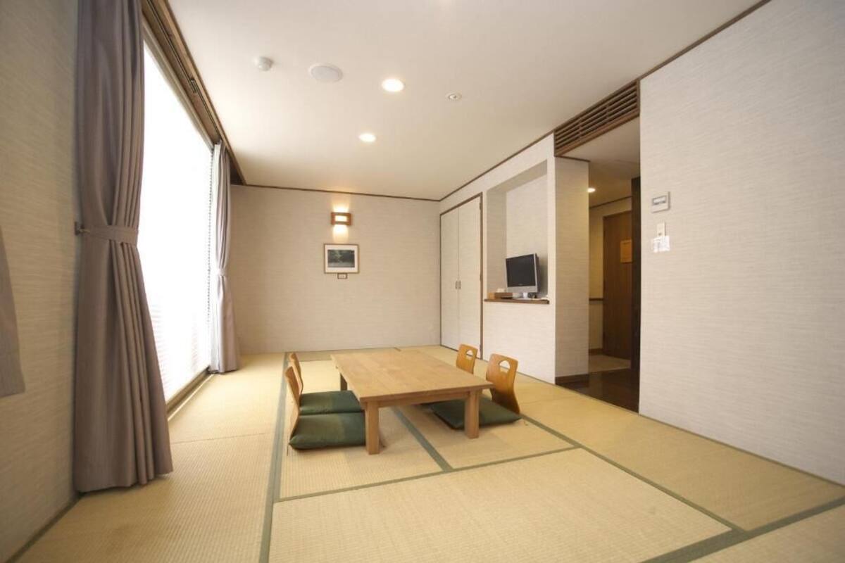 Ein traditioneller japanischer Raum mit Tatami-Böden, einem niedrigen Holztisch und Kissen.