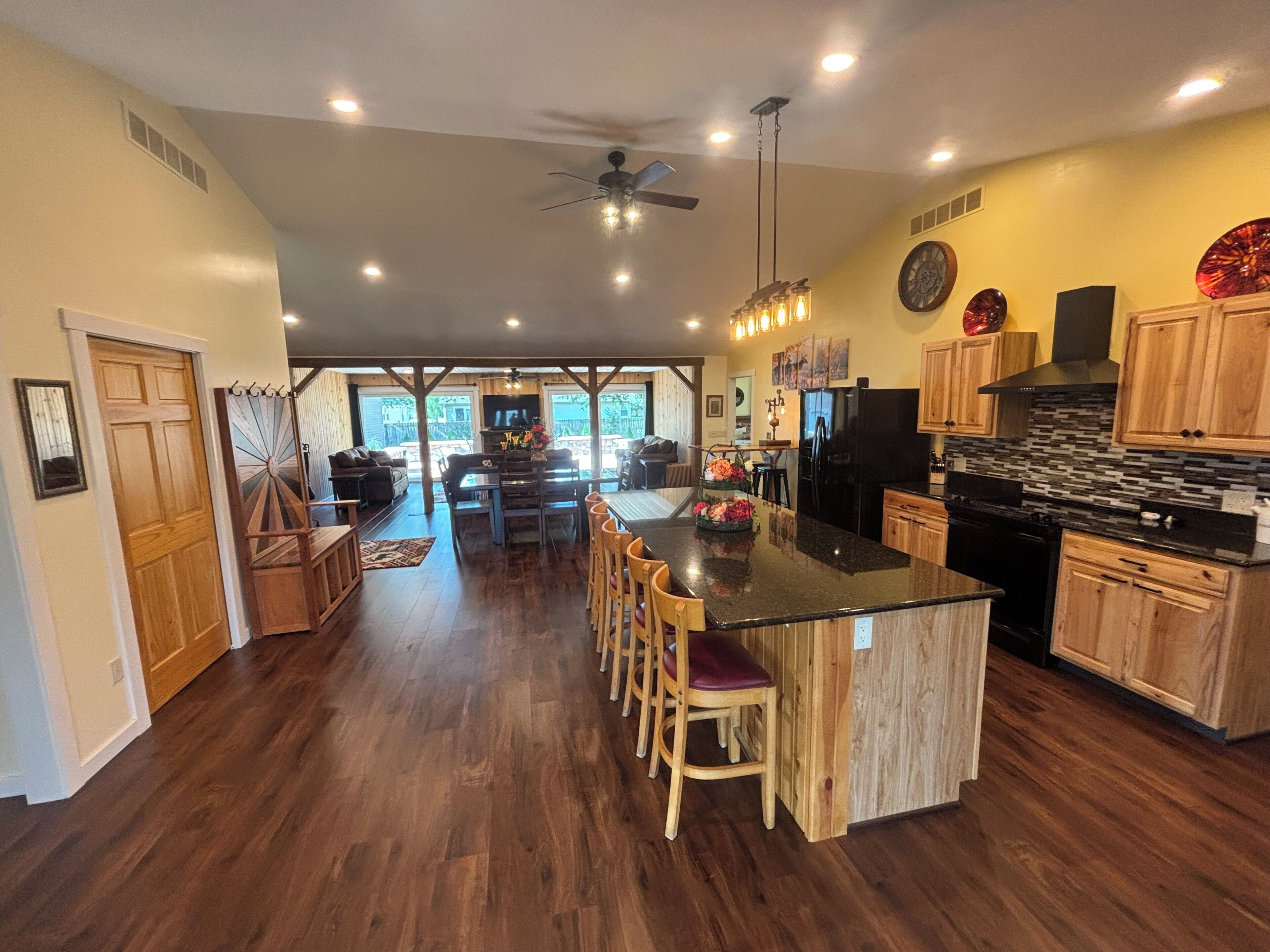 Una cocina amplia con una isla central, armarios de madera y un comedor con vistas.