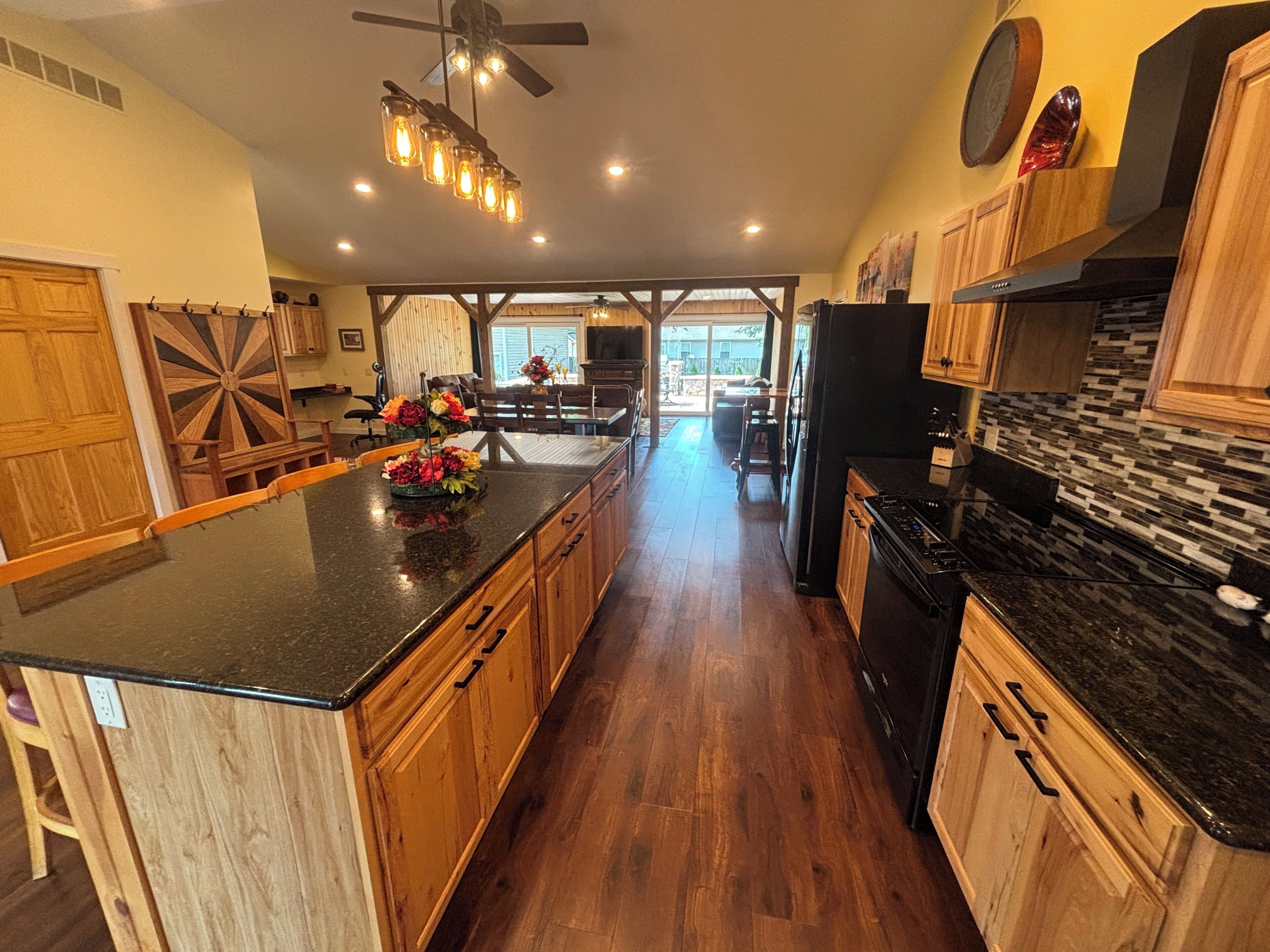 Una cocina amplia con armarios de madera, encimera de granito y una isla central decorada con flores.